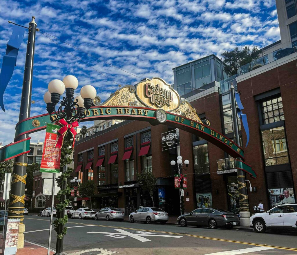 Historic heart of San Diego, family Christmas vacation ideas. Hard Rock Hotel in the background, with a sign welcoming people to the area in the foreground.