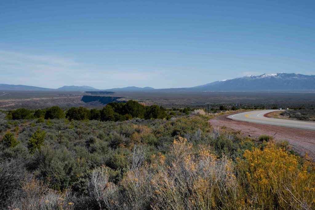 Windy road in Taos, New Mexico. Can see land just continuing into the background of the image.