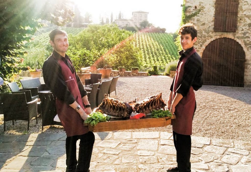 Two men holding tray of food Tuscany Trafalgar Be My Guest experience