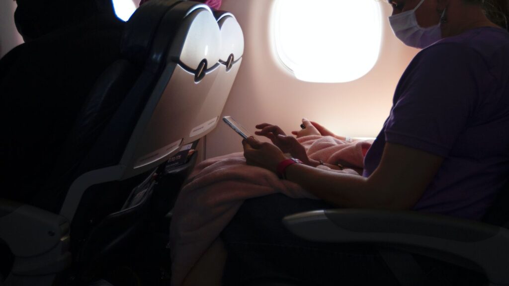 person wearing mask while travelling on an airplane