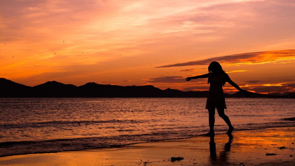 silhouette of a woman on a beach at sunset