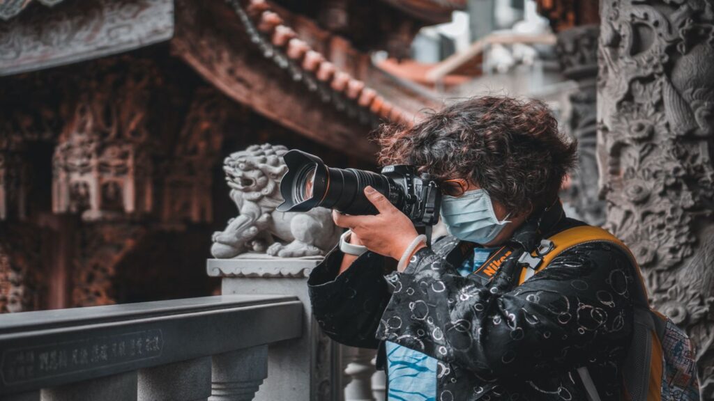 woman wearing a mask while taking a photo in a temple