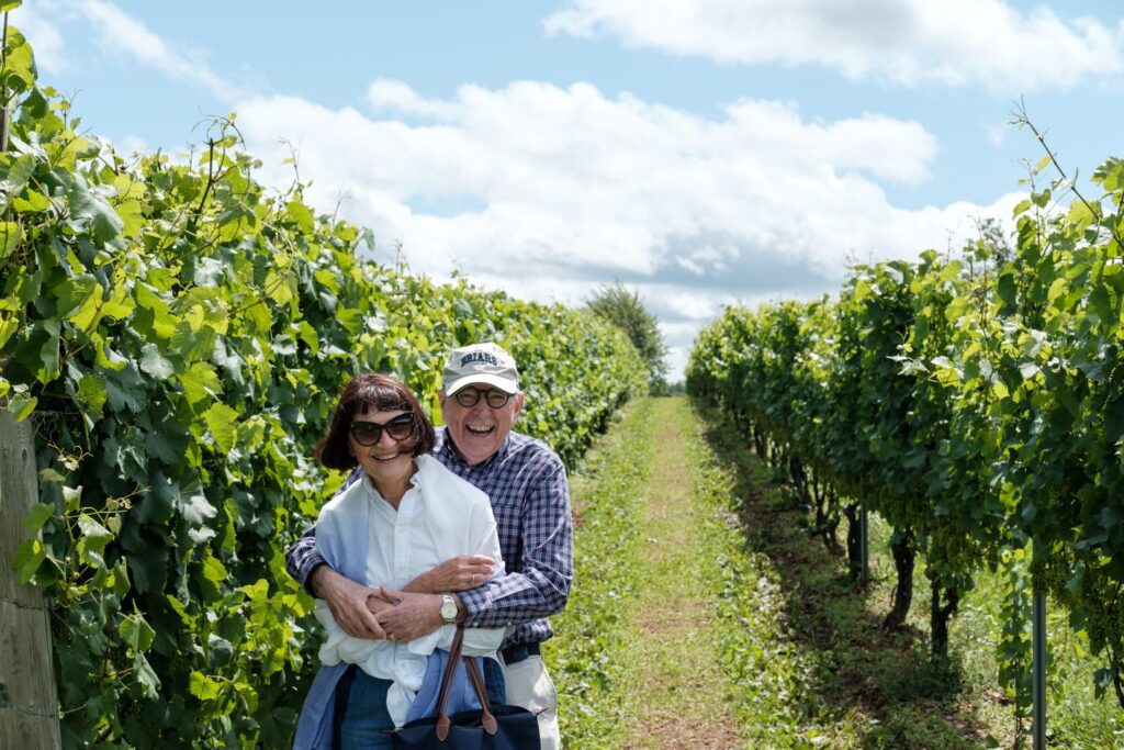 elderly couple hugging in vineyard