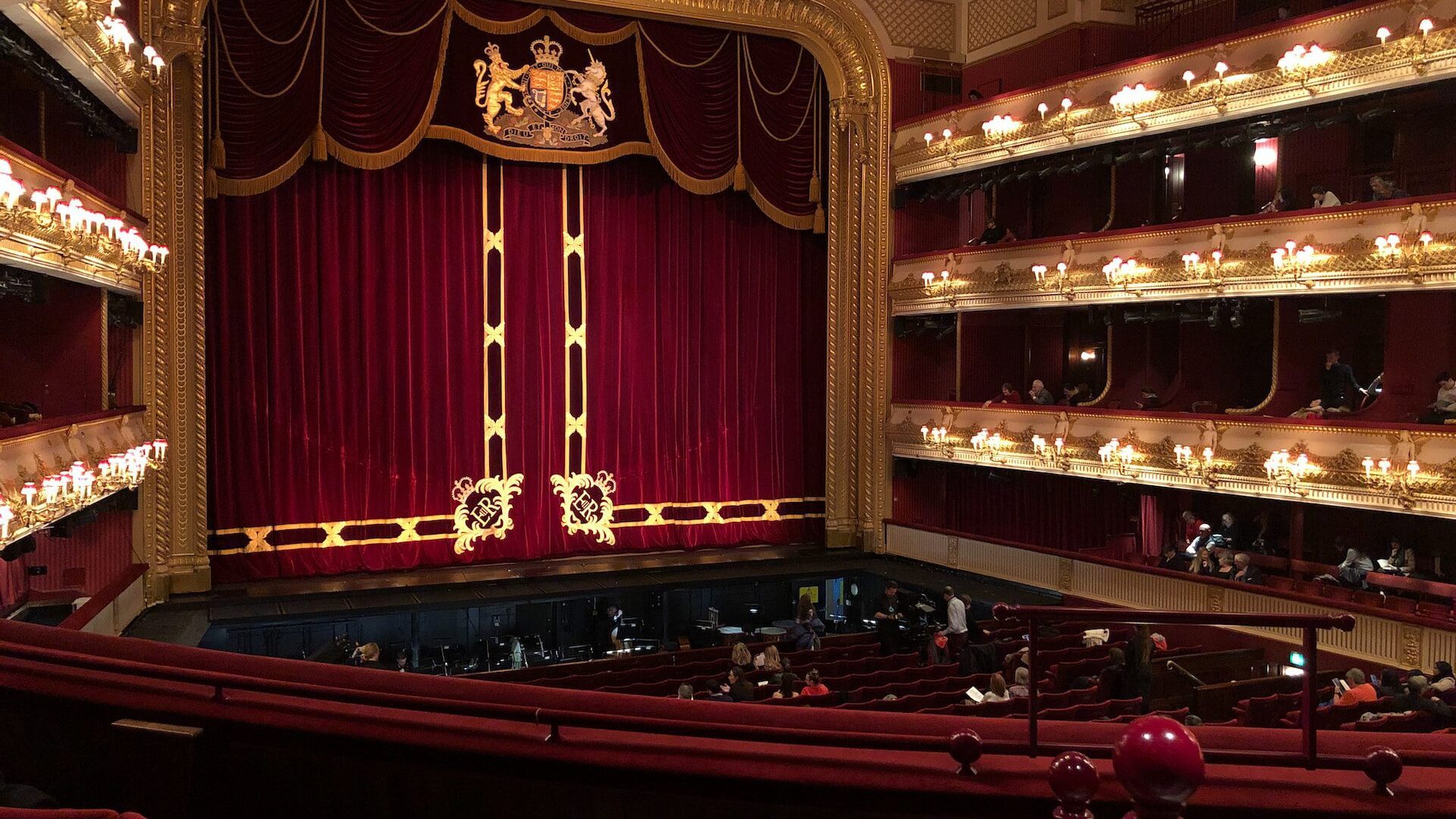 Image of the Royal Opera House, taken from the 2nd balcony tier, overlooking the stage with curtains drawn.