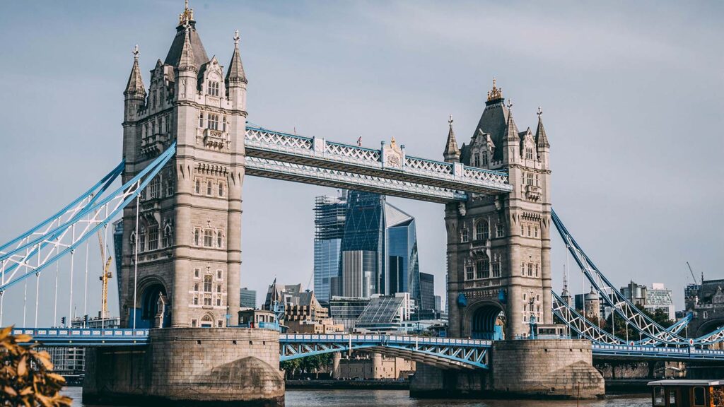 Tower Bridge in London, spanning over the River Thames with the modern city skyline in the background, is a highlight of city travel.