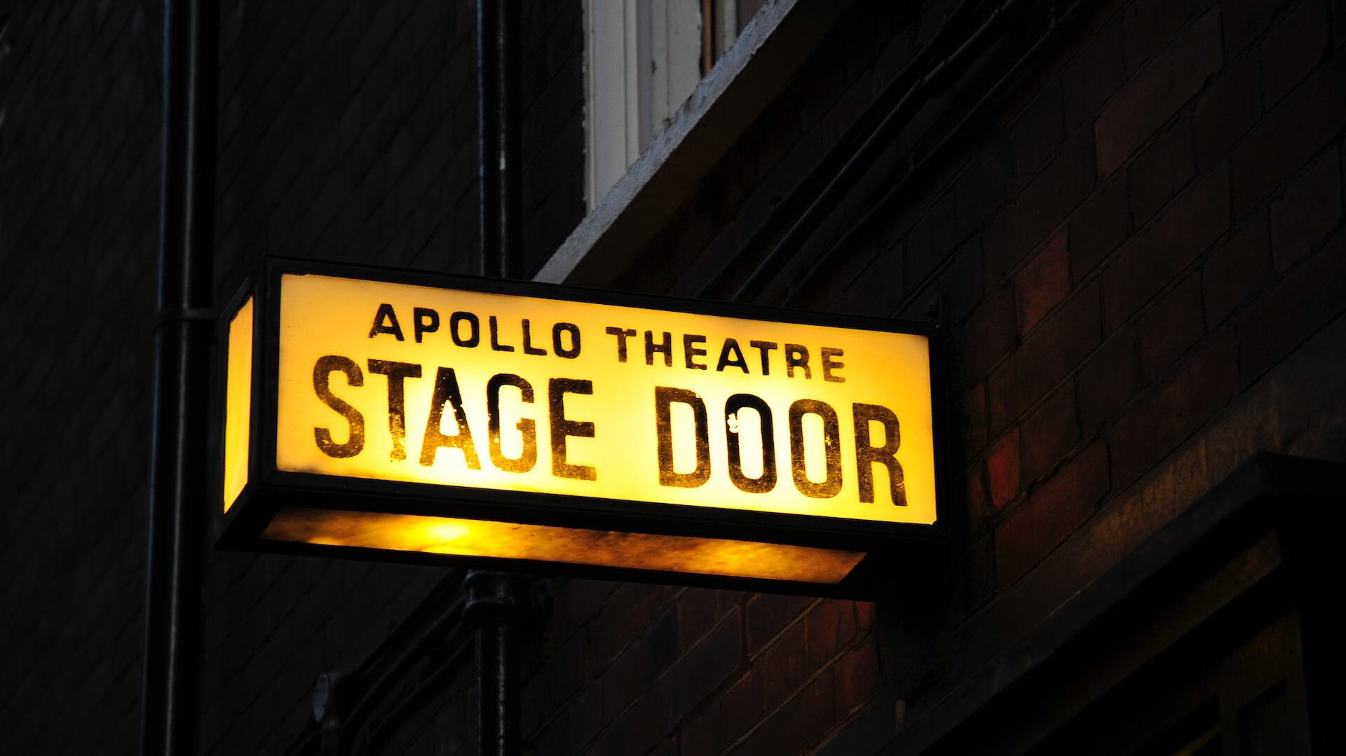Image of Apollo Theatre Stage Door sign, illuminated