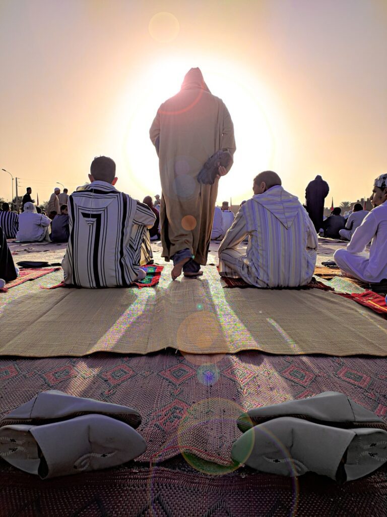 Muslim men praying at sunset celebrate Eid