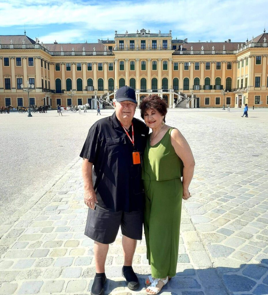 A couple standing in a square posing for a photo, in Europe