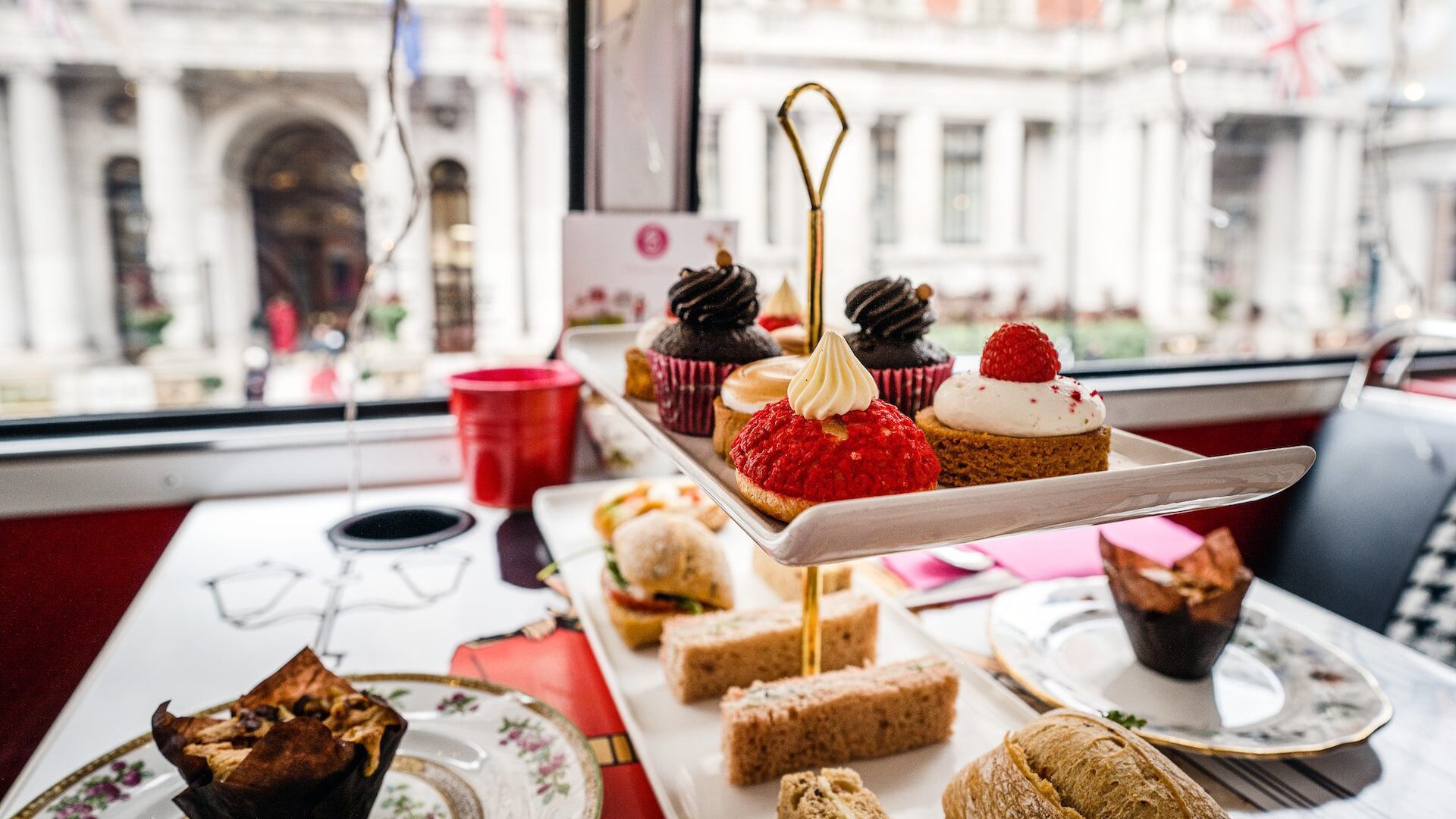 Image of a classic British afternoon tea, with small cakes and sandwiches