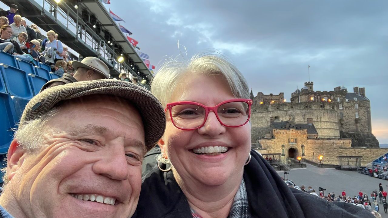 A couple smile for the camera while watching the Edinburgh Military Tattoo. 