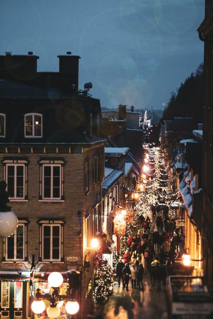 Quebec City at winter, overlooking a cobbled street with winter fairy lights and snow covering the rooftops.