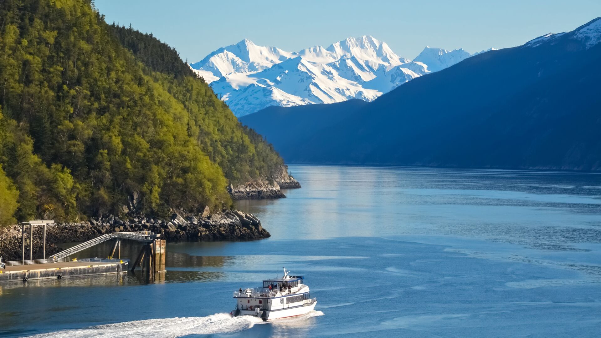 boat on water in Alaska with snow capped mountains