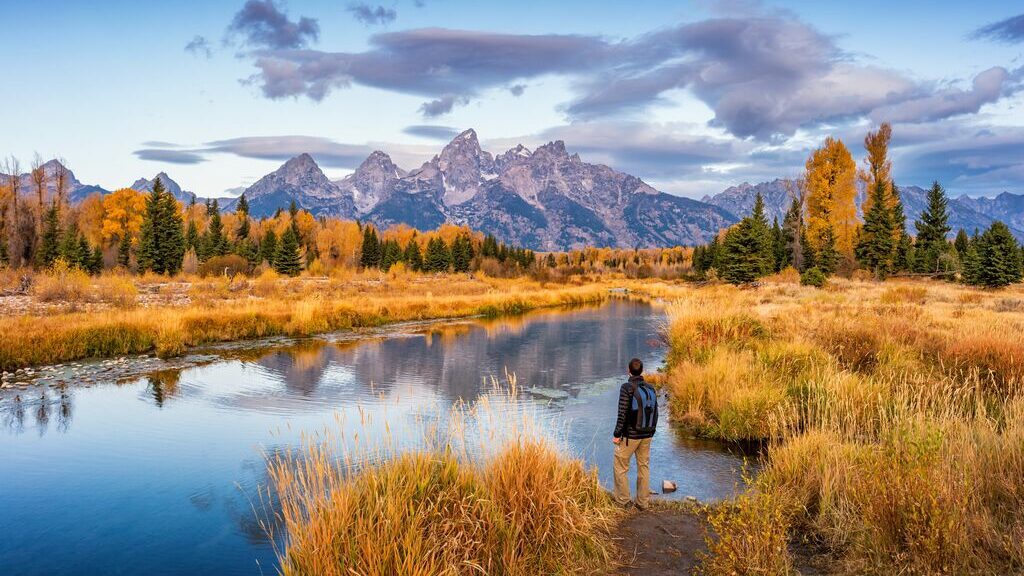 Hiker overlooking Gran Teton mountain range, Wyoming