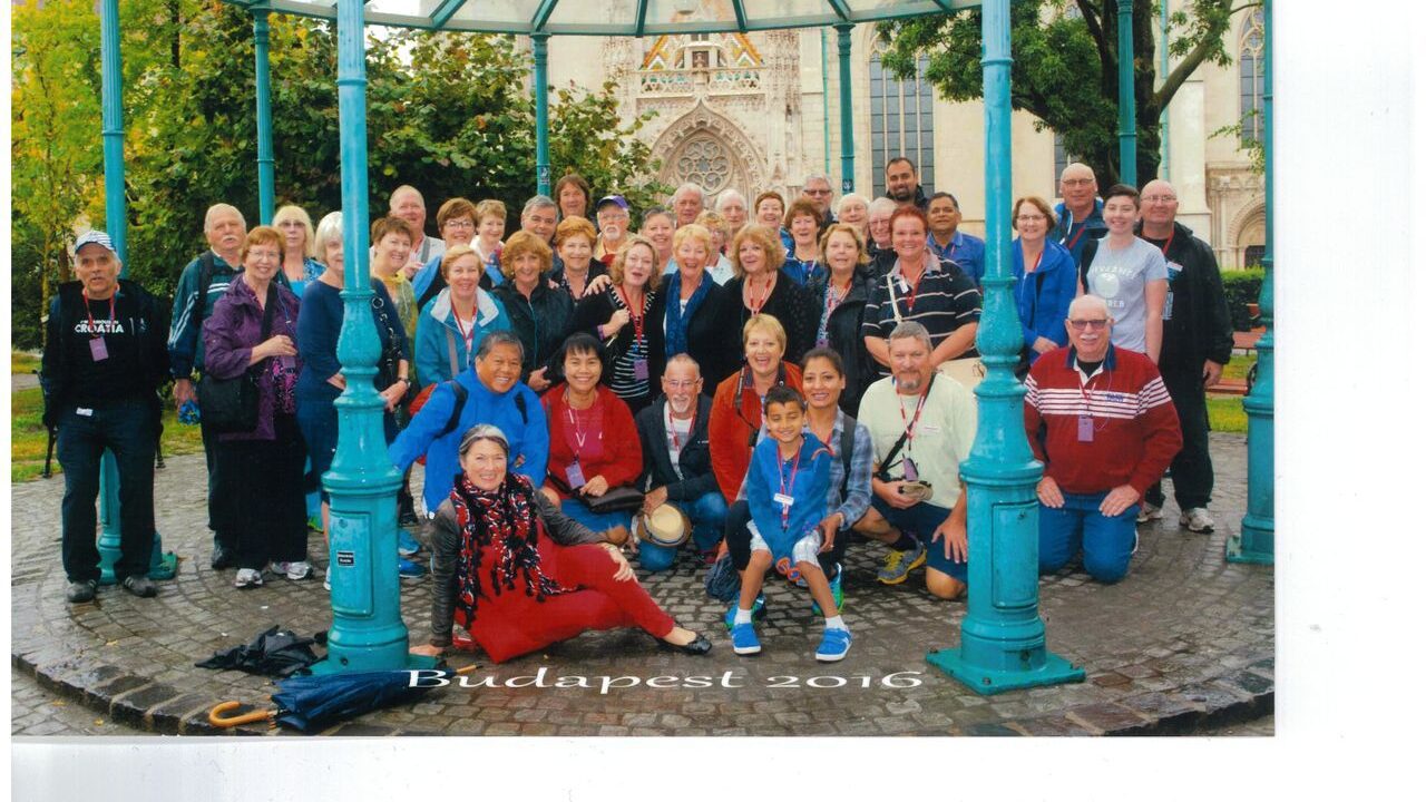 Large group of new friends posing for a photo in the middle of a covered square in Budapest