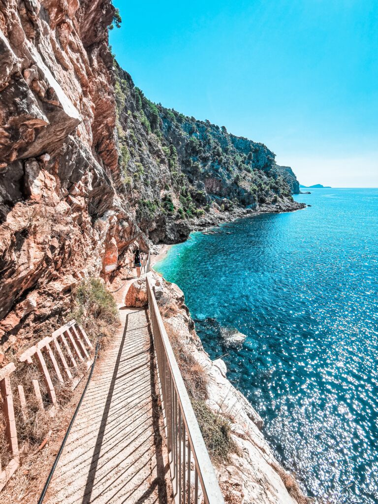 Stairway leading to Pasjaca Beach, Croatia, that just peeks out from behind the rocks, looking out onto the turquoise waters of the Adriatic.