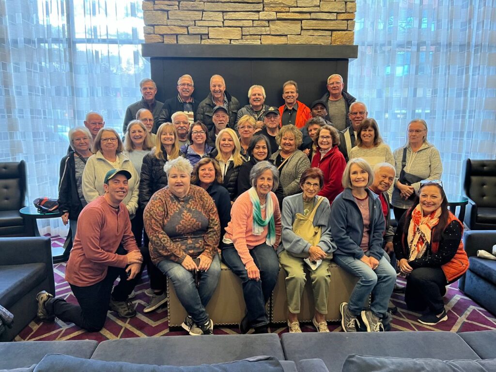 Large group of friends from a Trafalgar tour smiling for a photo, staggered.
