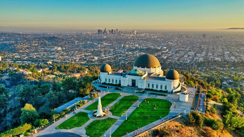 Aerial view of Griffith Observatory with downtown Los Angeles, one of the highest cost of living cities, in the background during sunset.