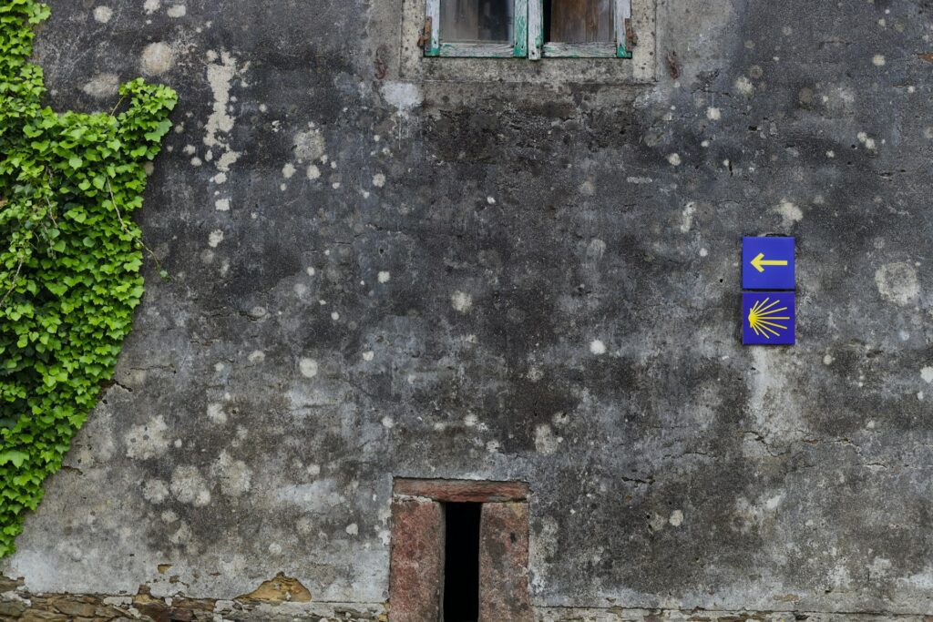Trail signs on an old stone building wall