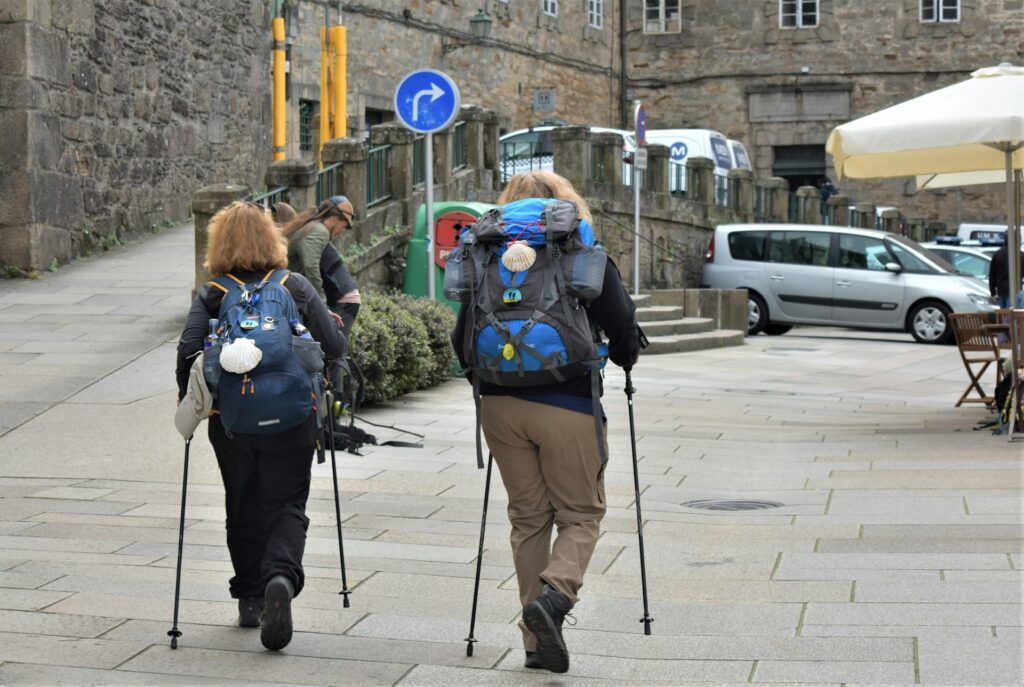 Two female hikers walking through a town centre