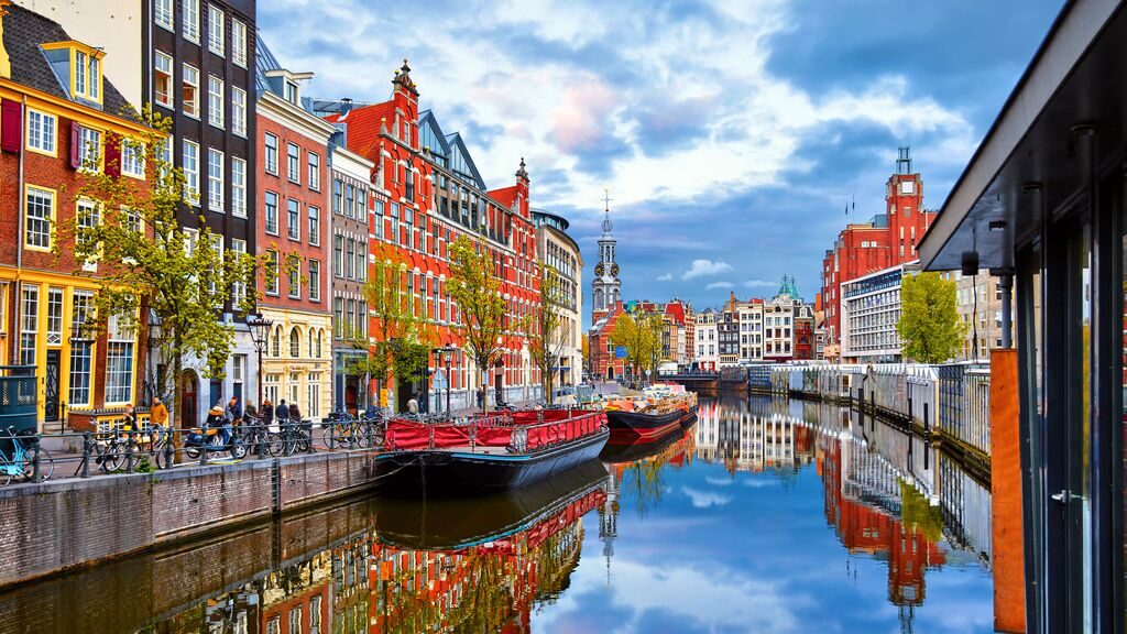 Canal and buildings in Amsterdam on a sunny day. Amsterdam is one of the best places to travel after a break up.