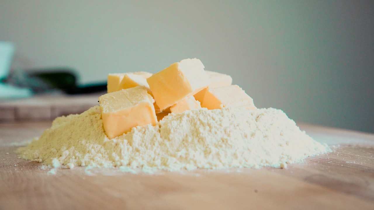 Cubed butter sitting on pile of flour