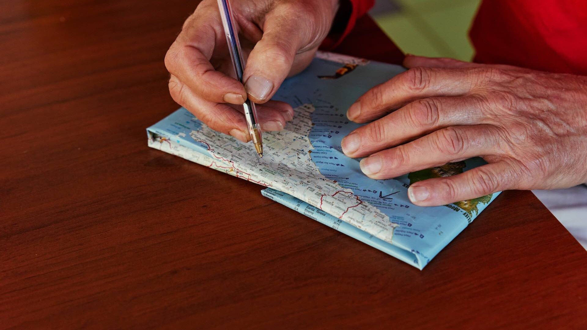 Close of someone highlighting locations on a map