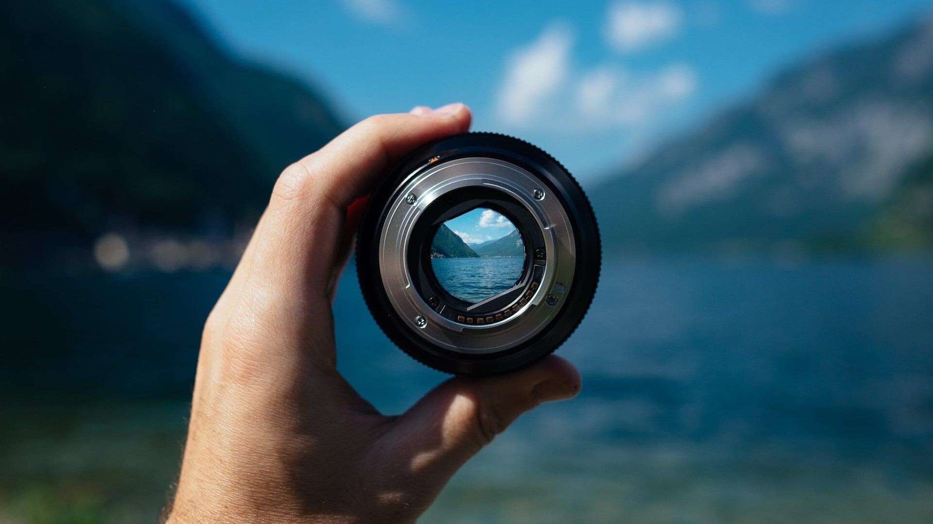 Camera lens with green mountainous valley and water