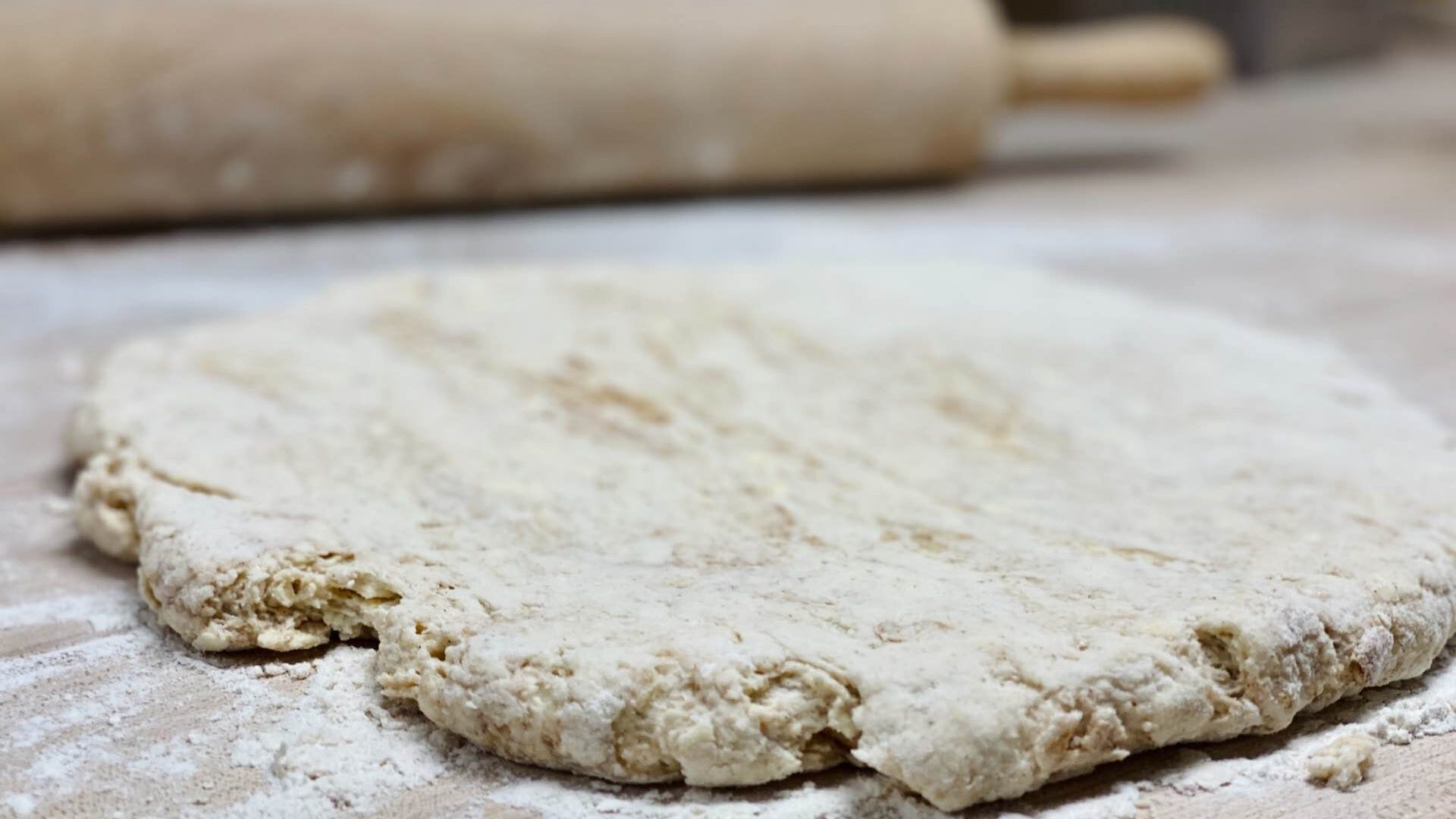 Biscuit dough on table with rolling pin
