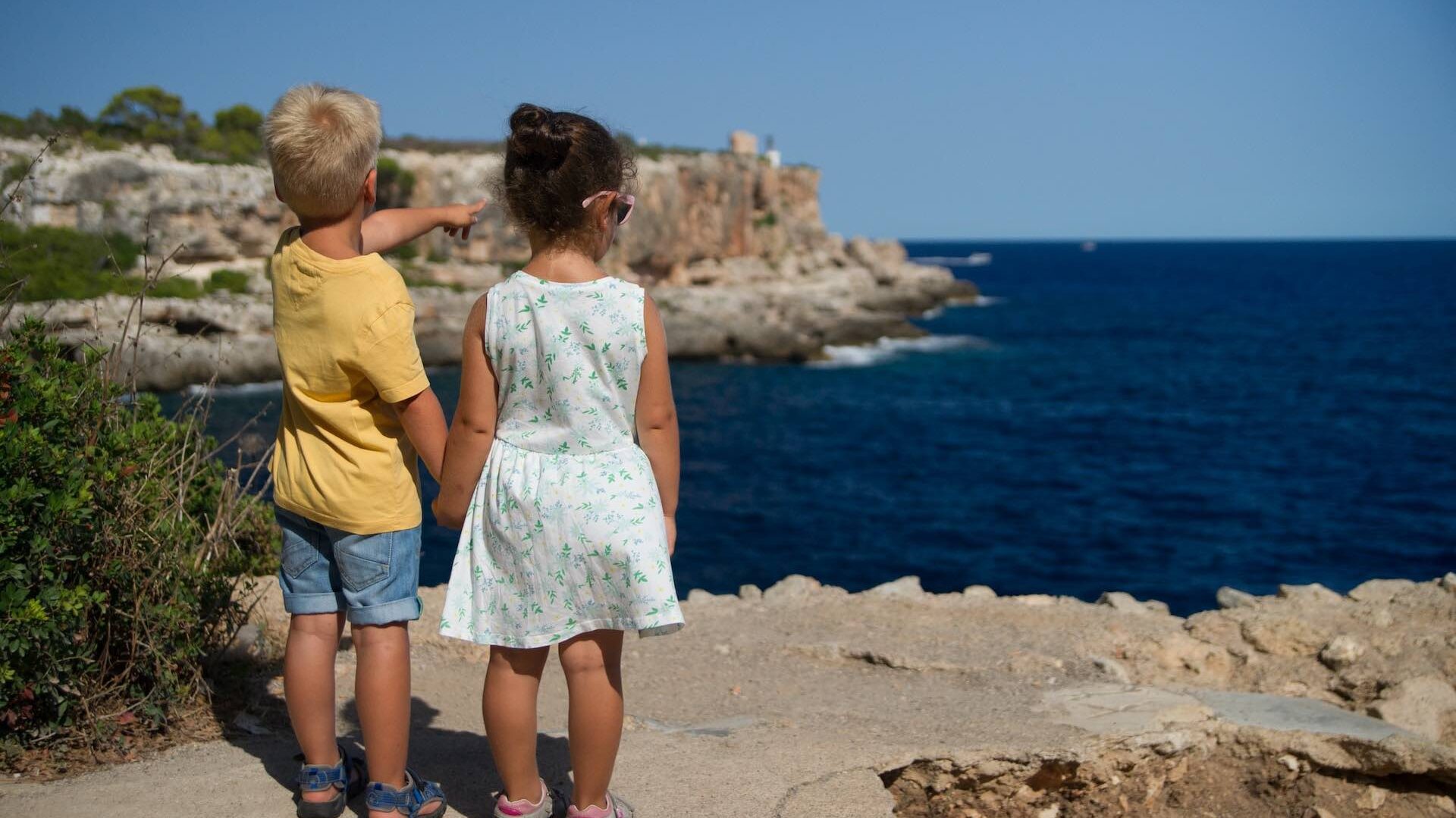 Boy and girl looking out to sea