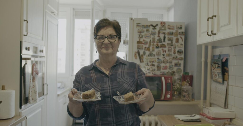 Senada holds up two portions of freshly made desert, in her kitchen in Sarajevo, Bosnia