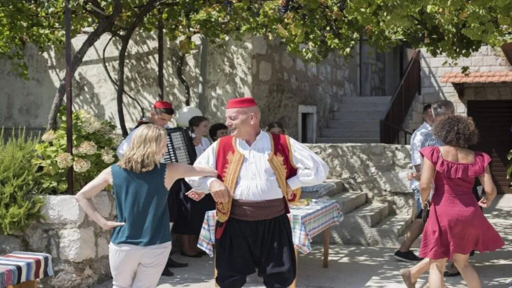 Muhoberac family teaching Trafalgar guests folklore dancing in Croatia