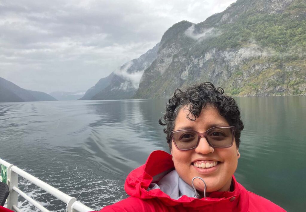 Trafalgar past guest Adriano on a boat with mountains behind her
