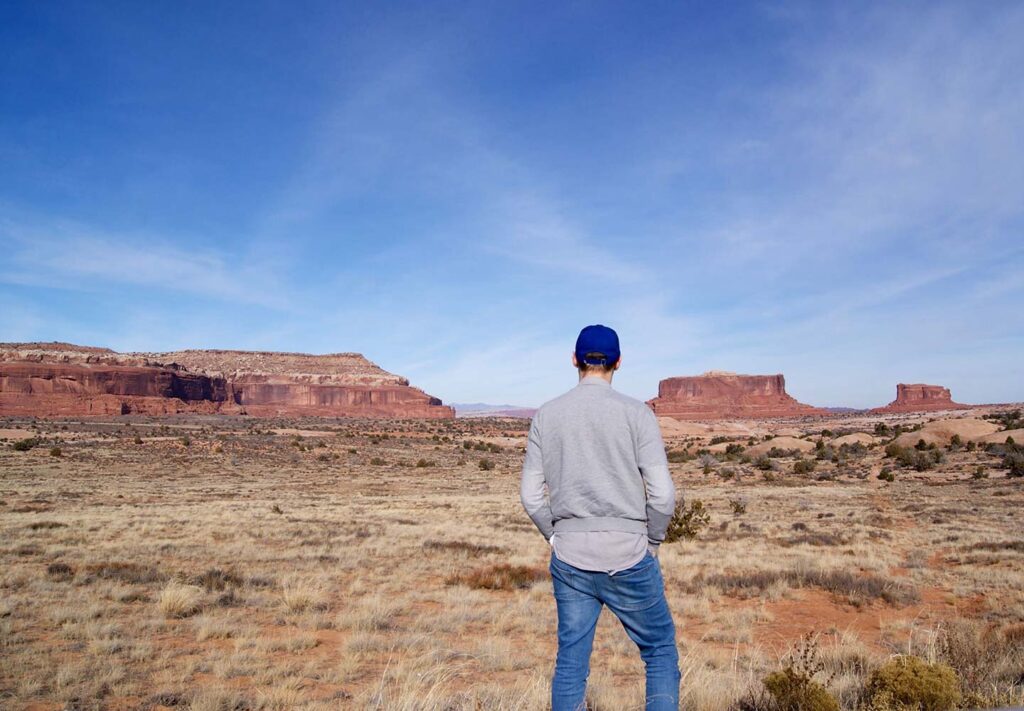 Alex standing looking out at the landscape of Utah, facing away from the camera