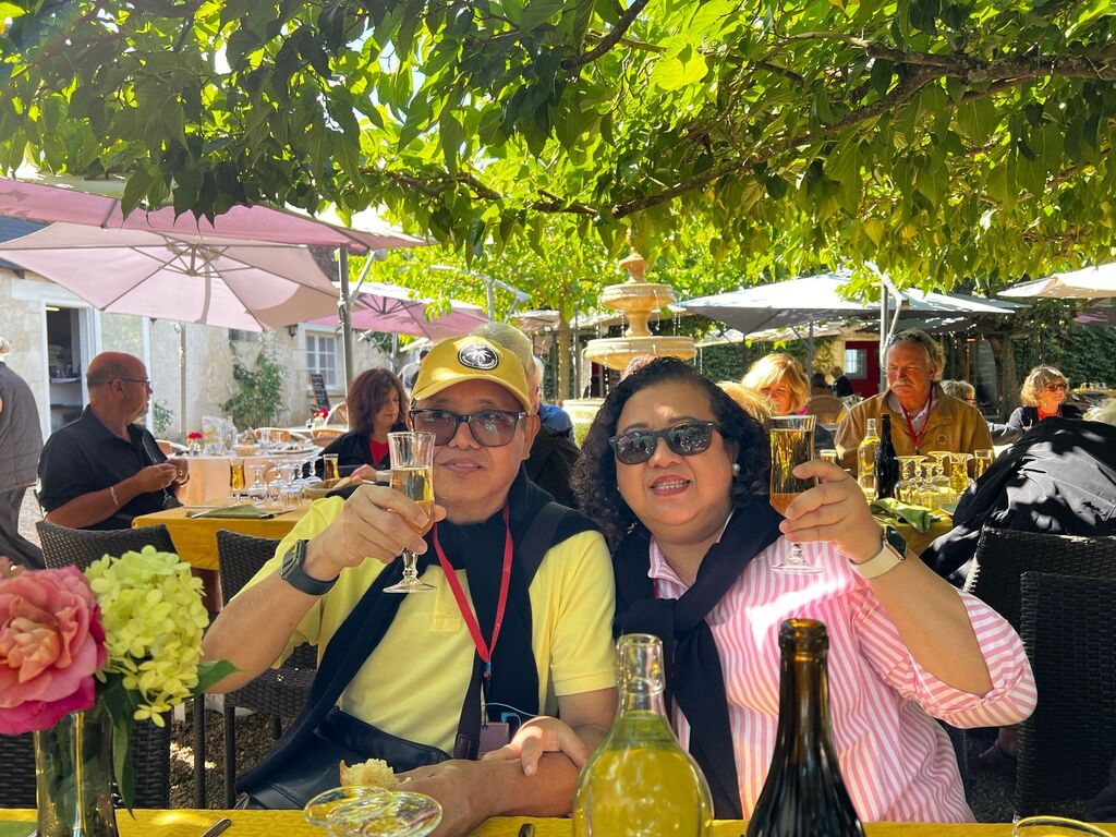 Past Trafalgar guest Anna Marie Lynn L B enjoying a drink at an outdoor cafe in France