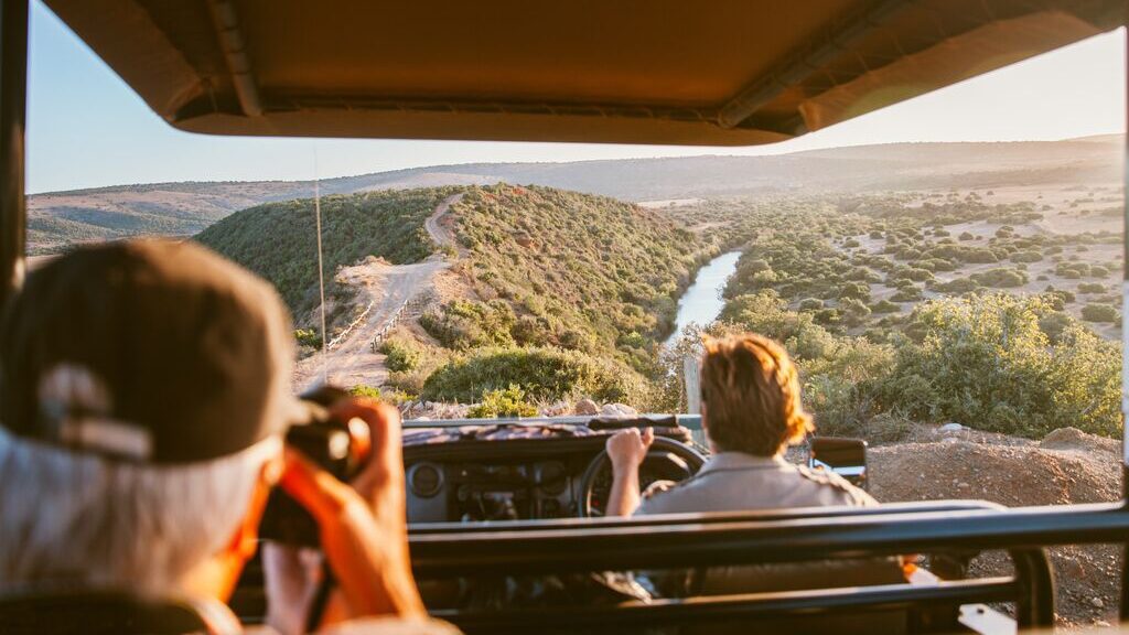 Photo from passenger's point of view inside a safari jeep, looking ahead at the dirt road.