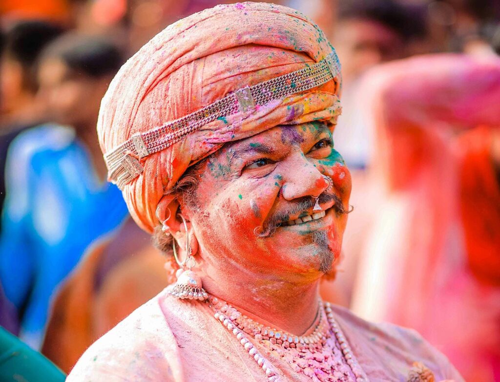 An Indian man covered in Holi color