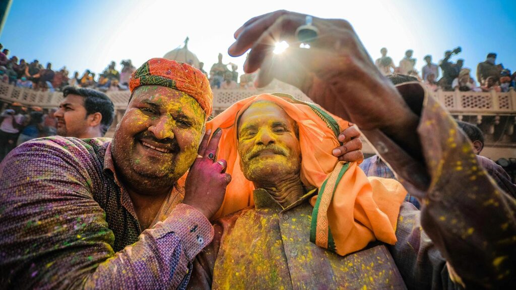 Two men with yellow Holi color on their faces