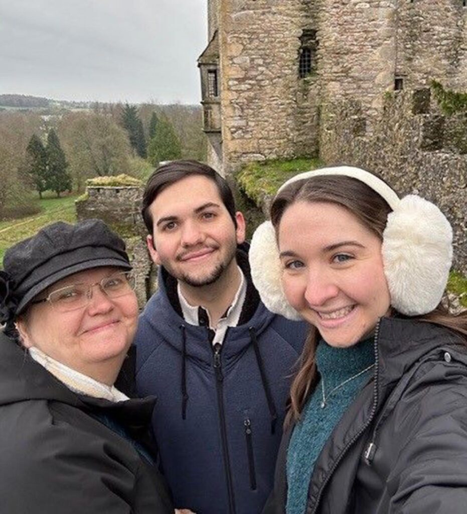 Selfie photo of Joy with her son and daughter in front of a castle in Ireland