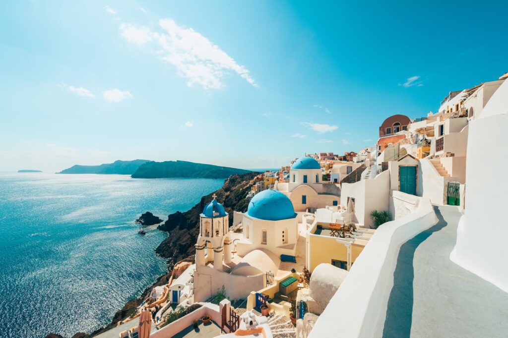 Bright blue domed roofs and white buildings of Santorini in Greece glistening the sunlight
