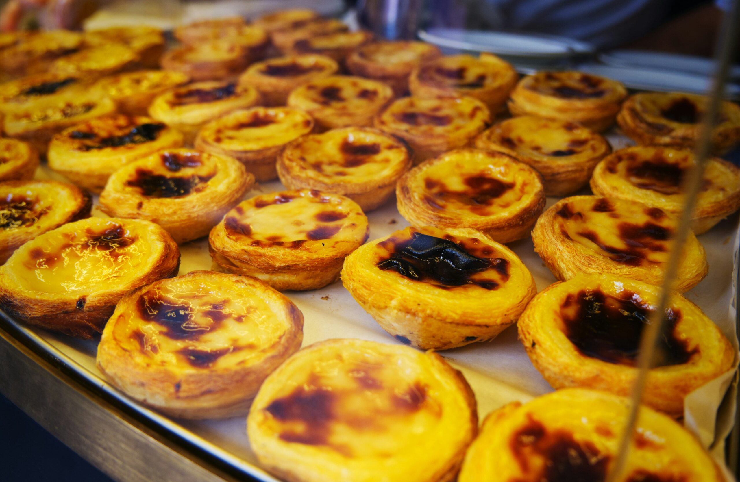 Pastel de nata tarts on a baking tray