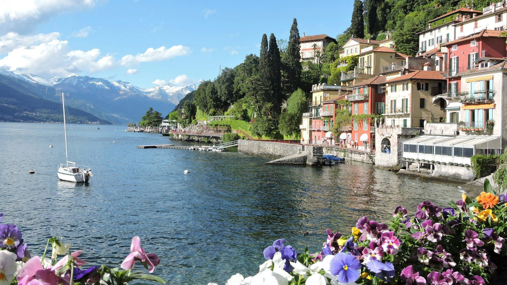 View across Lake Como with a small sailing boat in the foreground