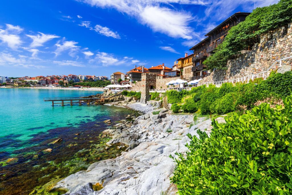 The coastline in Bulgaria: pale blue waters, red roof buildings and old stone walls