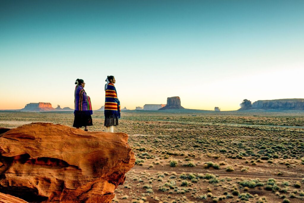 Two-Traditional-Navajo Native American Sisters In Monument Valley at sunrise