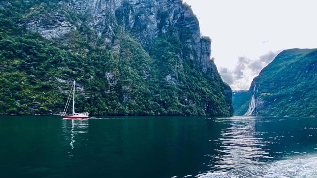 A boat floating along the waters of a Norwegian Fjord