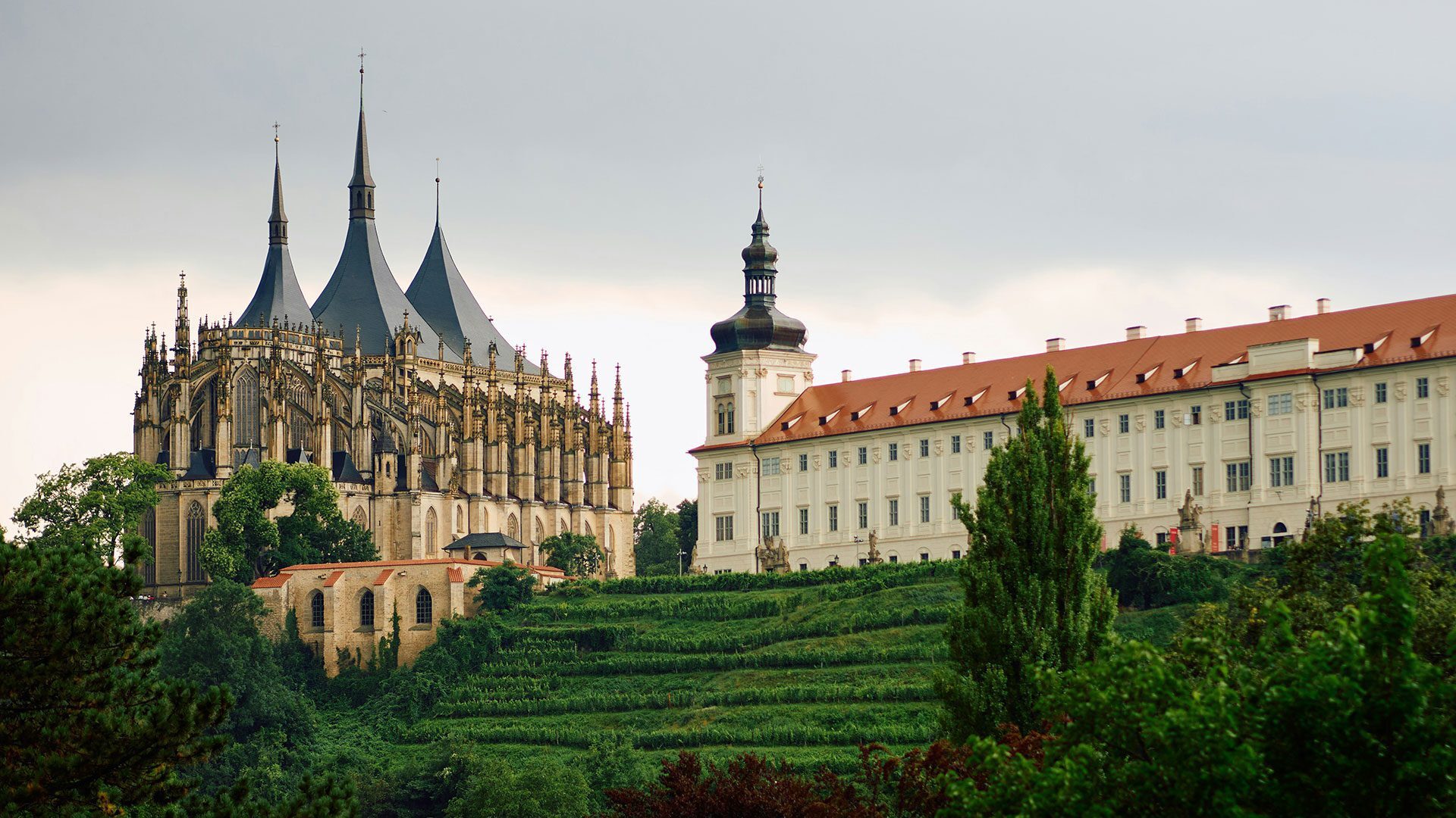 A historic cathedral standing on a hill next to a white palace with a terracotta room