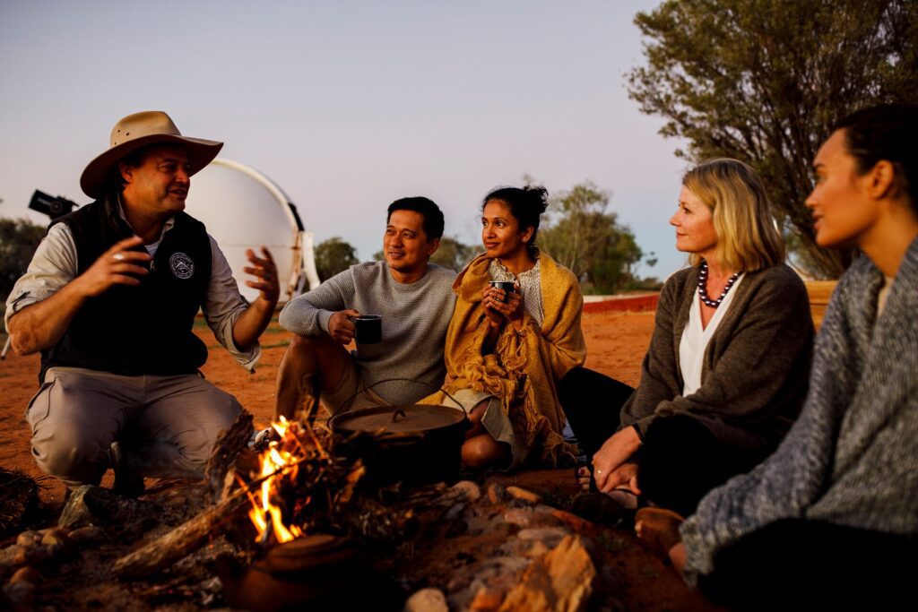 Group sitting round a fire and pot in Australia