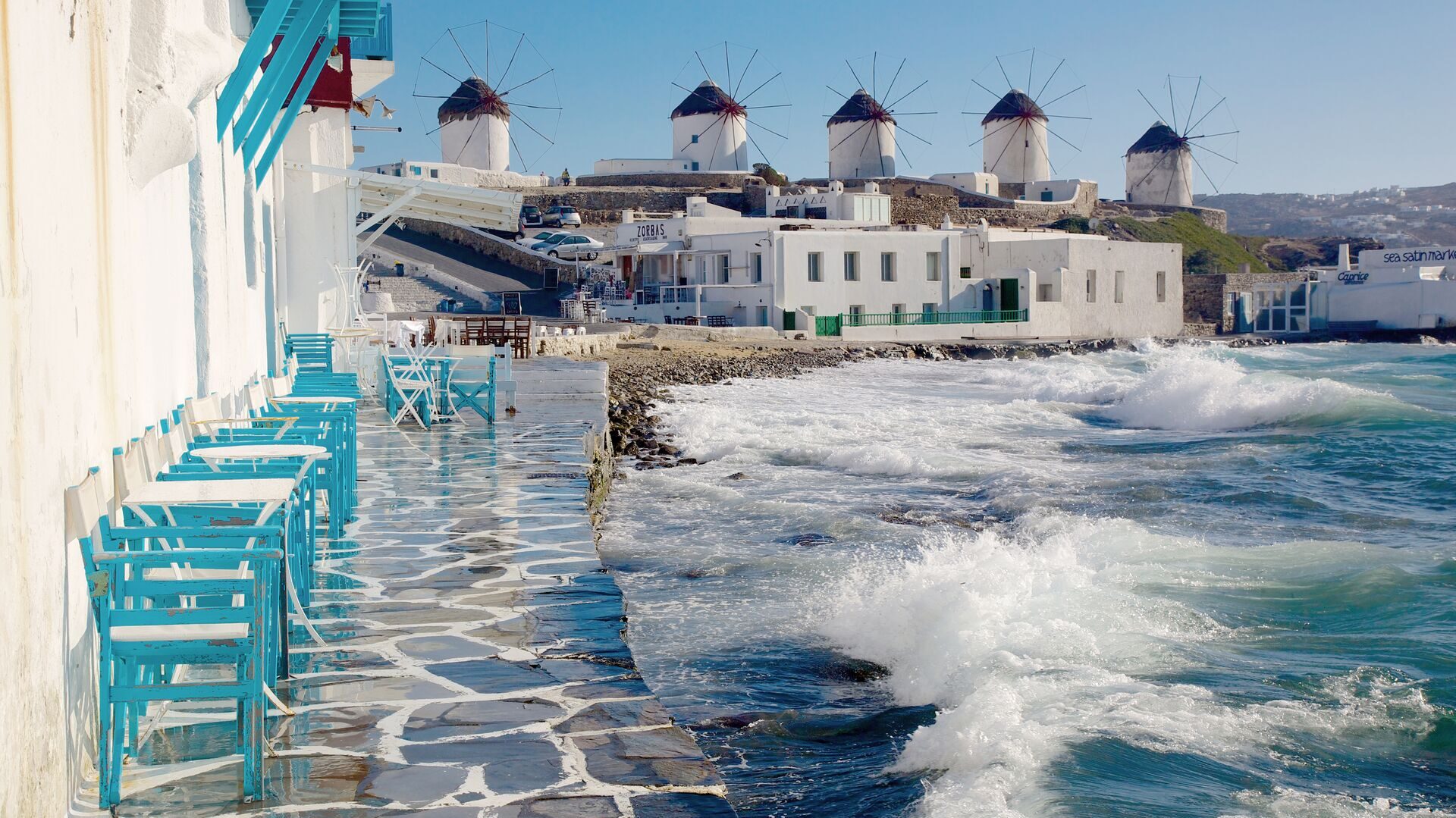waterfront cafe and view of windmills in mykonos
