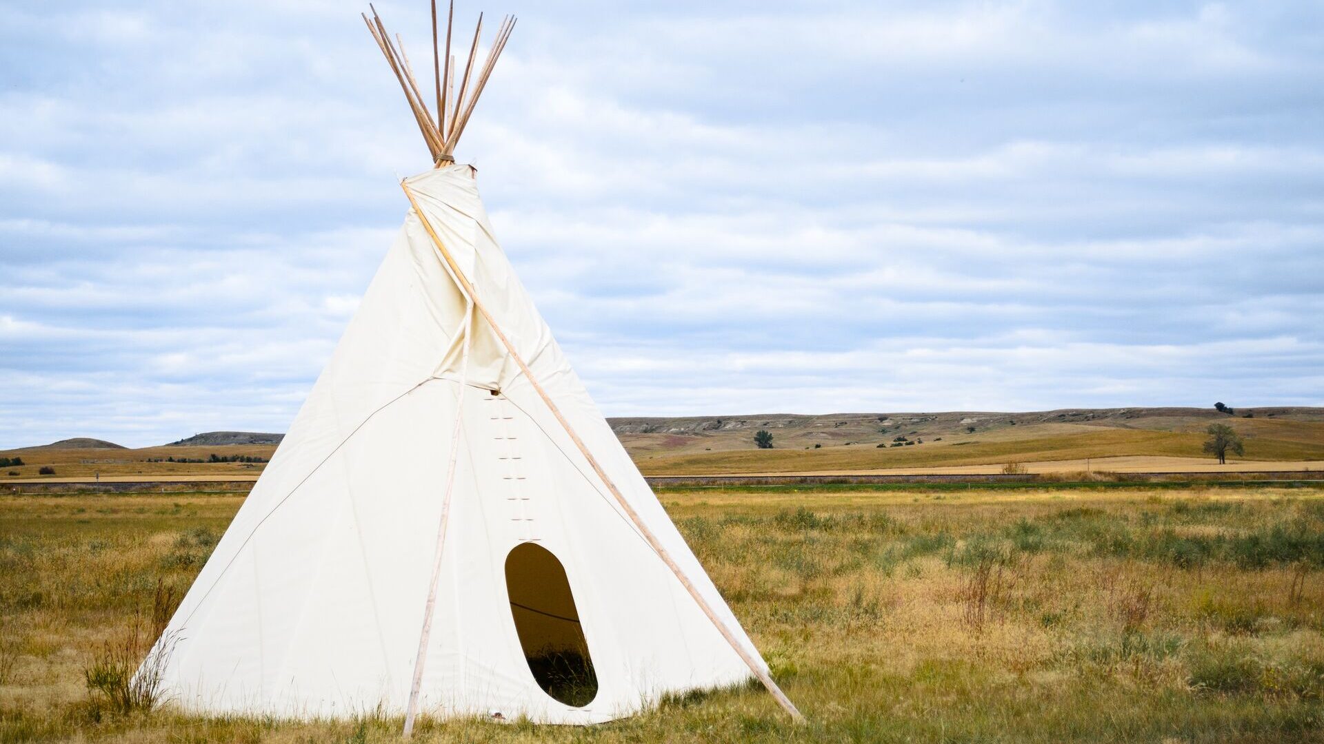 A teepee tent in the middle of a prairie
