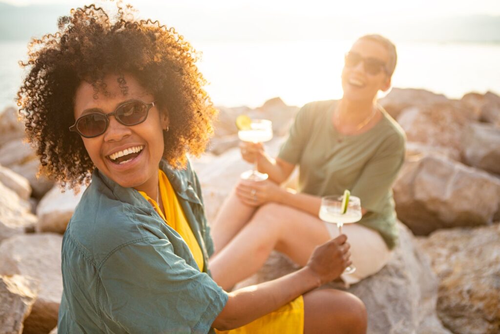 Two woman laughing on their group tour, with cocktail glasses in their hands