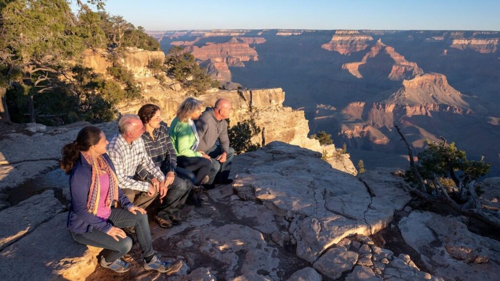 A group of five travelers looking out at the Grand Canyon